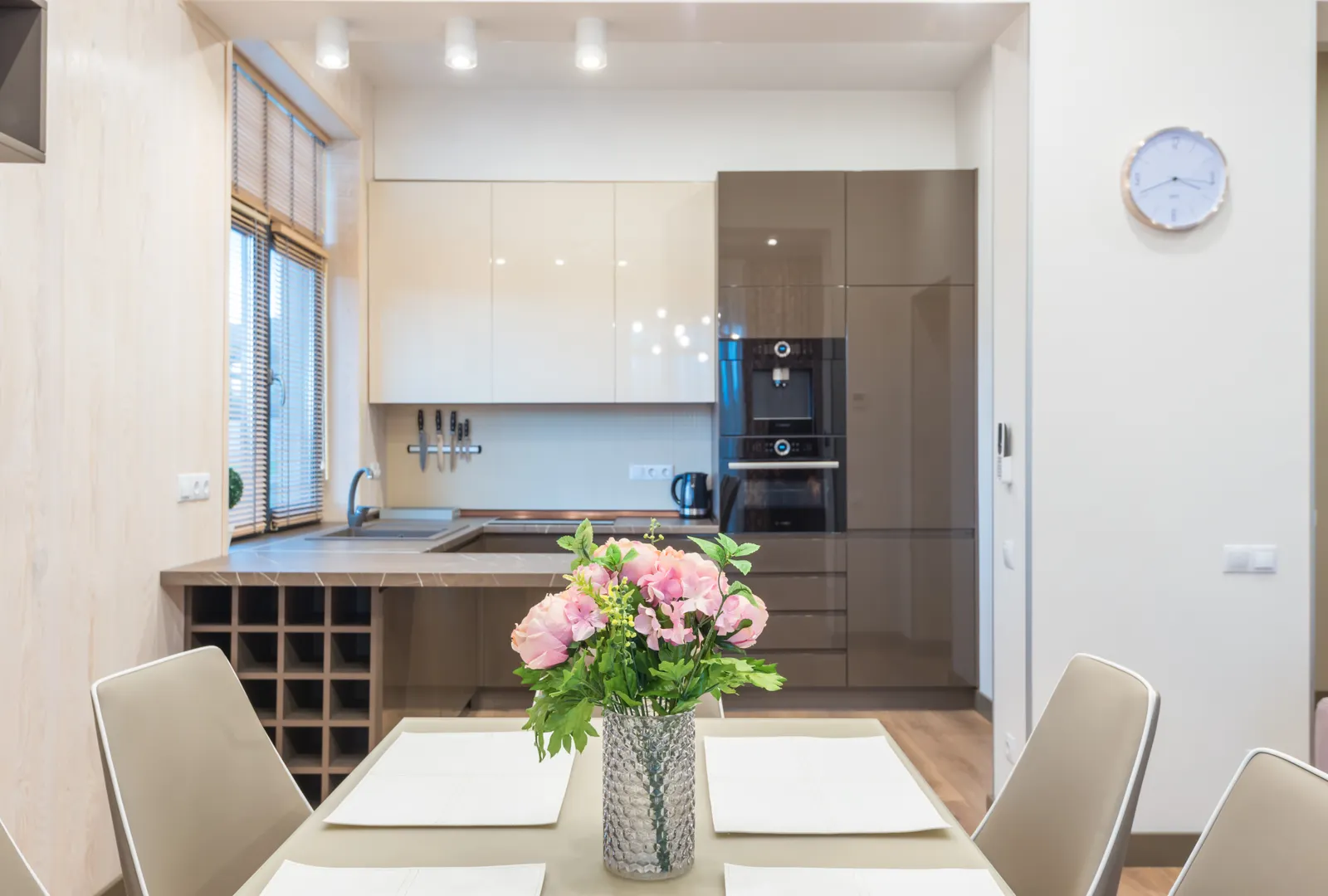 Bright, tidy kitchen and dining space with flowers